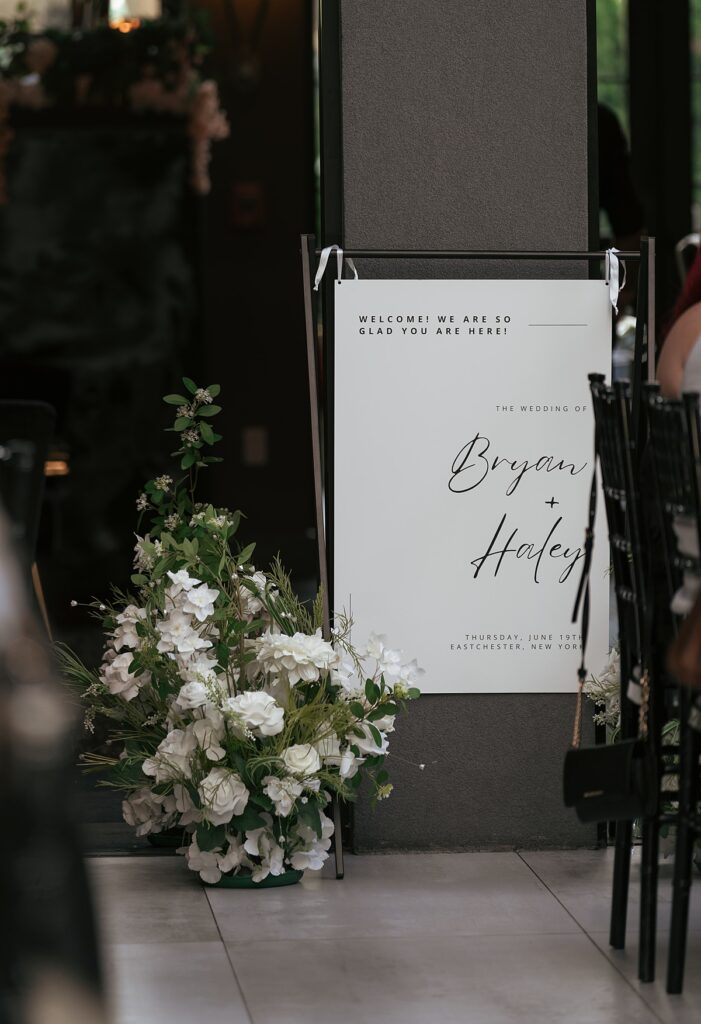 A welcome sign & wedding florals are photographed by a Westchester wedding photographer 