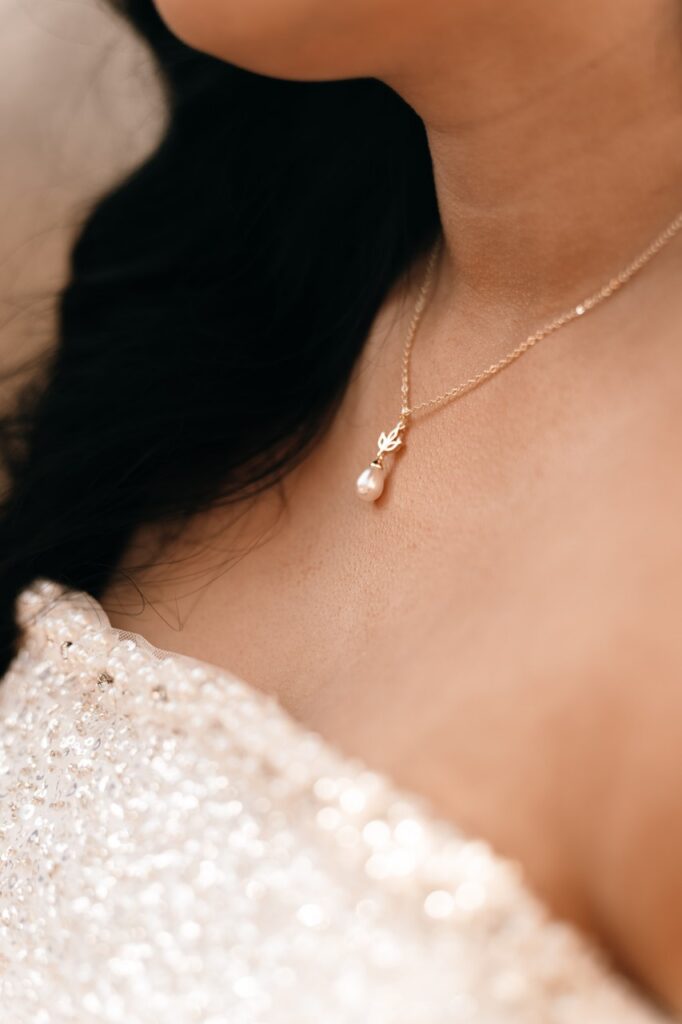 A bridal detail close up showcases a bridal gown neckline & necklace in an image taken by a NYC elopement photographer. 