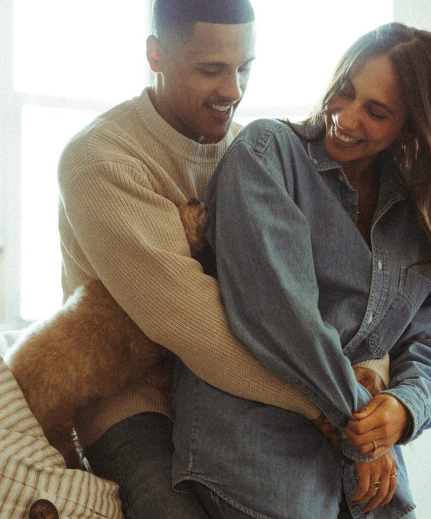 A newly engaged couple pose in their Bronx apartment during in-home engagement pictures NYC.