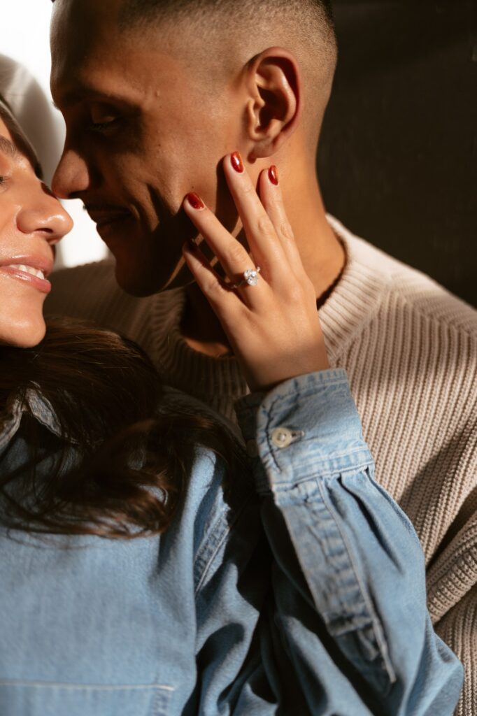 A diamond solitare engagement ring on the hand of a newly engaged woman is the focal point of this image taken by an NYC engagement photographer. 