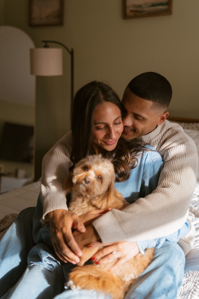 A newly engaged couple poses with their dog in an image taken by a NYC engagement photographer. 