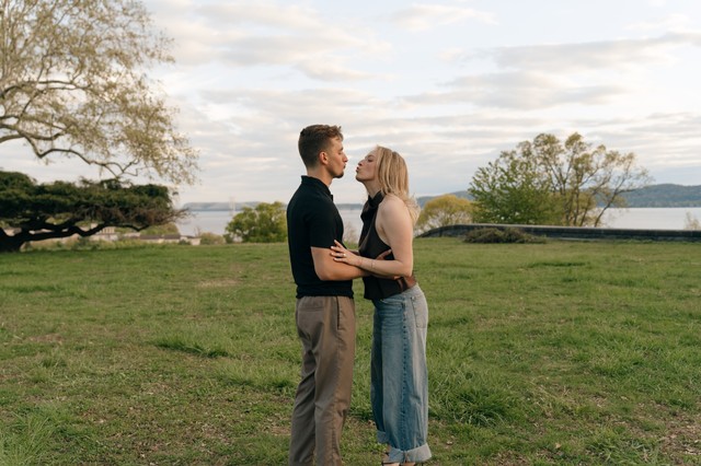 A NY couple shares a kiss in a photo taken at an engagement session at Rockwood Hall State Park.