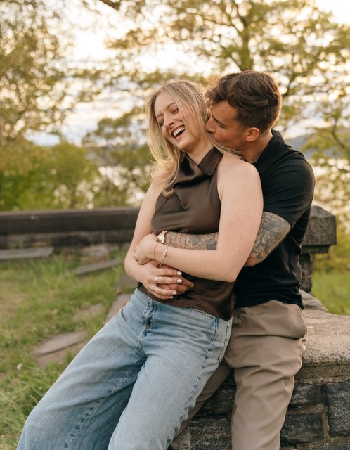 A Couple laughs in a scenic area of Rockwood Hall State Park during a new york engagement session.