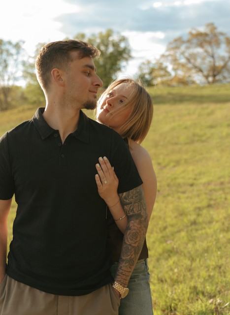 A woman hugs her soon-to-be-husband from behind in an engagement photo taken at Rockwood Hall State Park.
